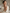 Smiling woman in a cream robe holding Xtressé FR Concentrate Serum